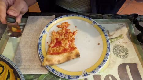 person eating pizza with fork and knife