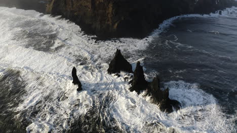 Descripción-Aérea-Inclinándose-Sobre-Las-Rocas-Reynisdrangar-En-La-Costa-Invernal-De-Islandia