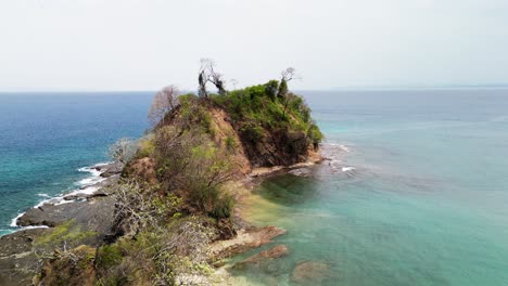 Aerial-shot-of-rocky-cliff-in-a-tropical-beach-in-Playa-Blanca,-Costa-Rica