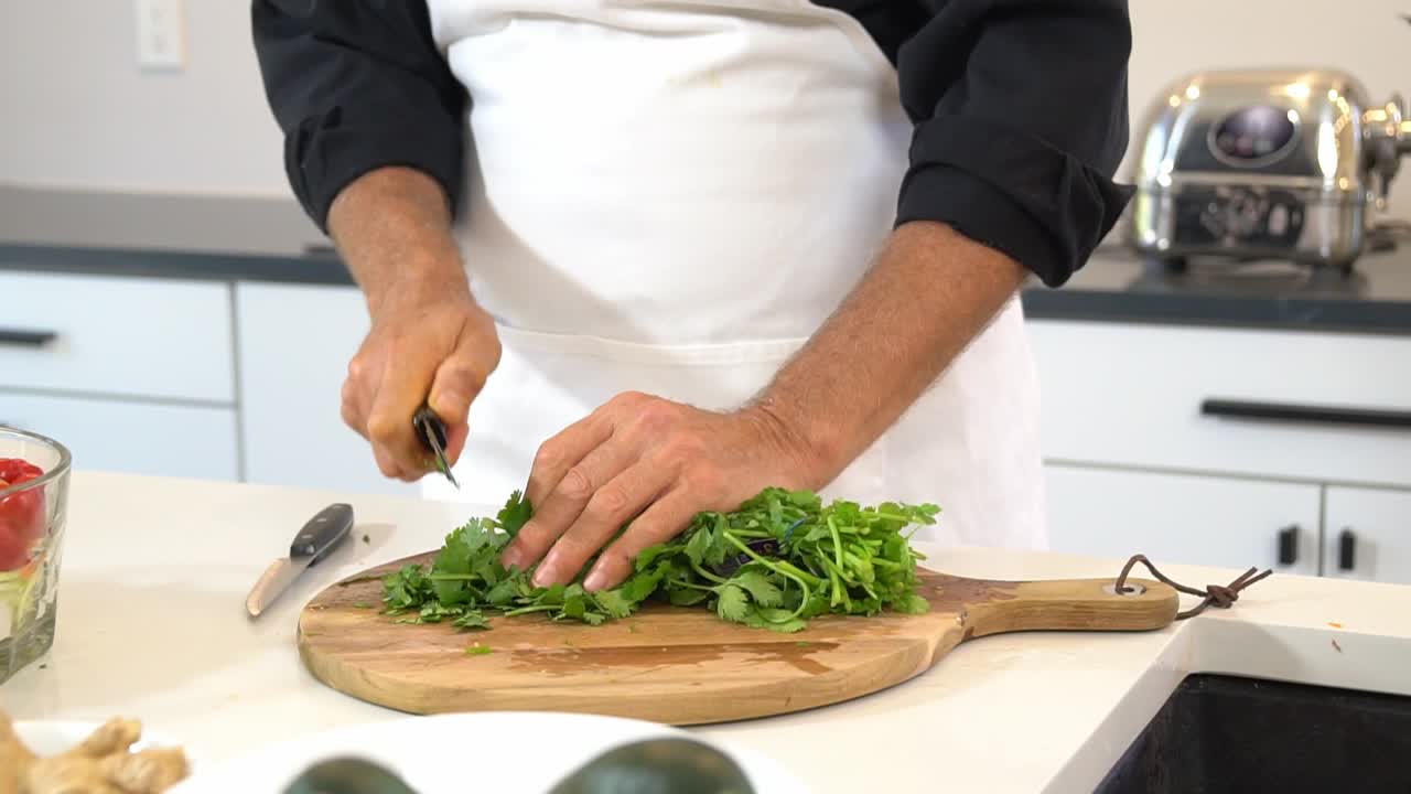 cortar cilantro y agregarlo al tazón para hacer fideos de calabacín zoodles agregar al tazó un estilo de vida vegetariano y vegano saludable dieta de desintoxicación
