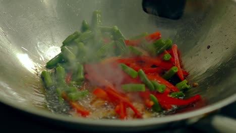 Close-up-slow-motion-shot-Cooking-fresh-vegetables-on-hot-frying-pan-add-them-to-pre-toasted-potatoes