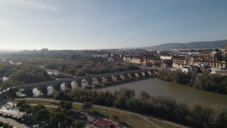 slow aerial pan of roman bridge and mosque-cathedral of cordoba across river