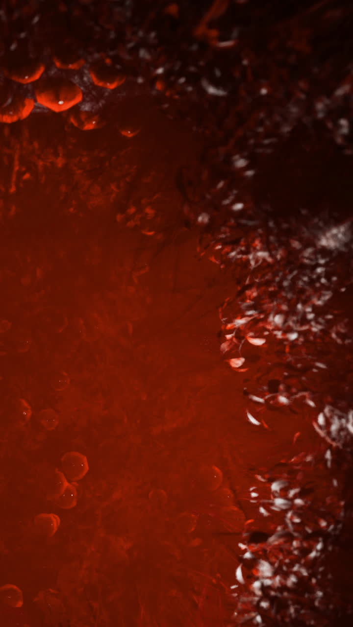 Vivace texture astratta che riflette profonde tonalità cremisi in forma liquida