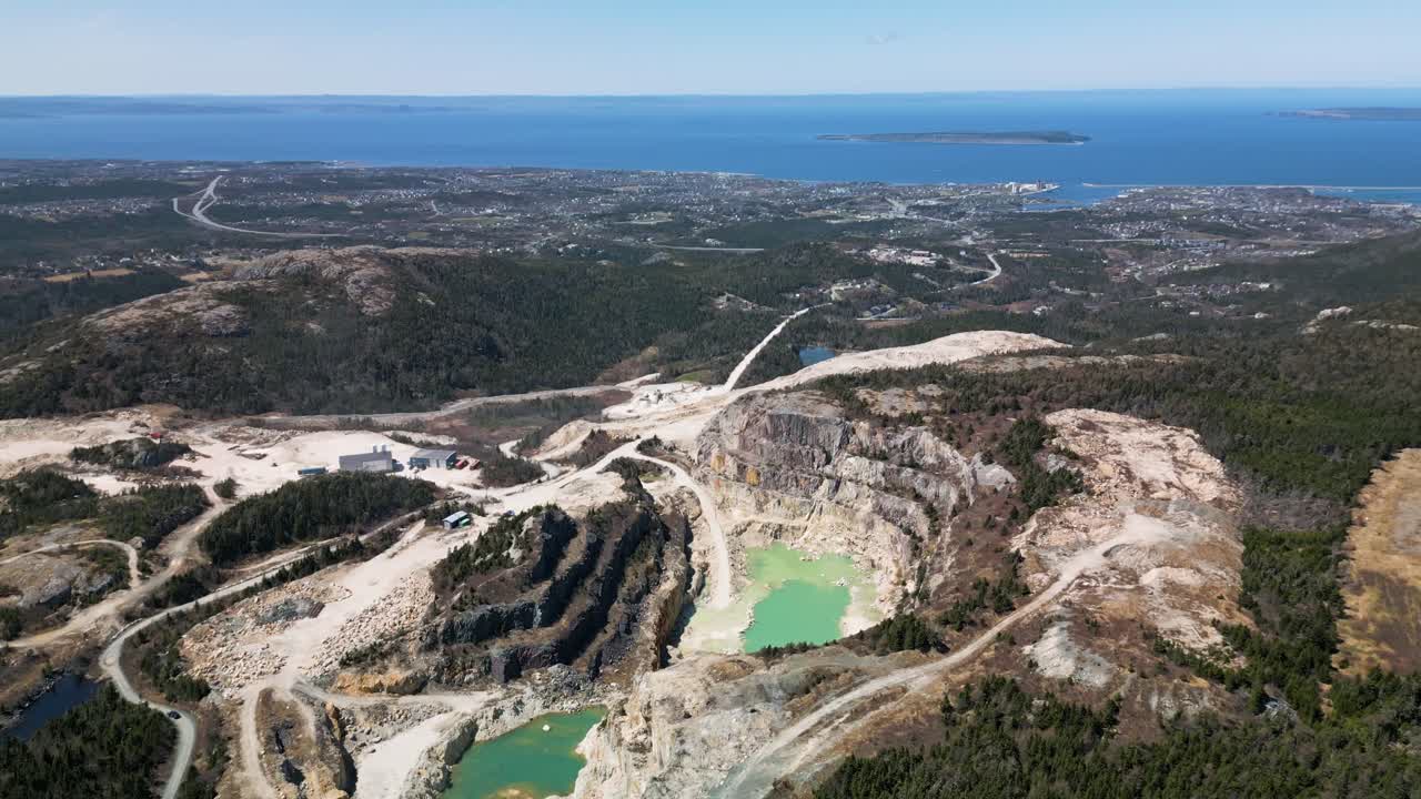 Drone shot of an open talc (pyrophillite) mine in Manuels, Newfoundland, Canada displaying Conception Bay South in the background