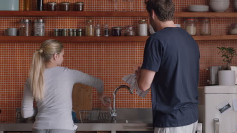 happy couple playing in kitchen washing dishes dancing having fun enjoying relaxing weekend together at home