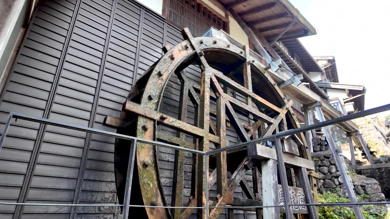 Large wooden waterwheel powering Magome juku, a post town during the Edo period in Japan, showcasing traditional Japanese engineering