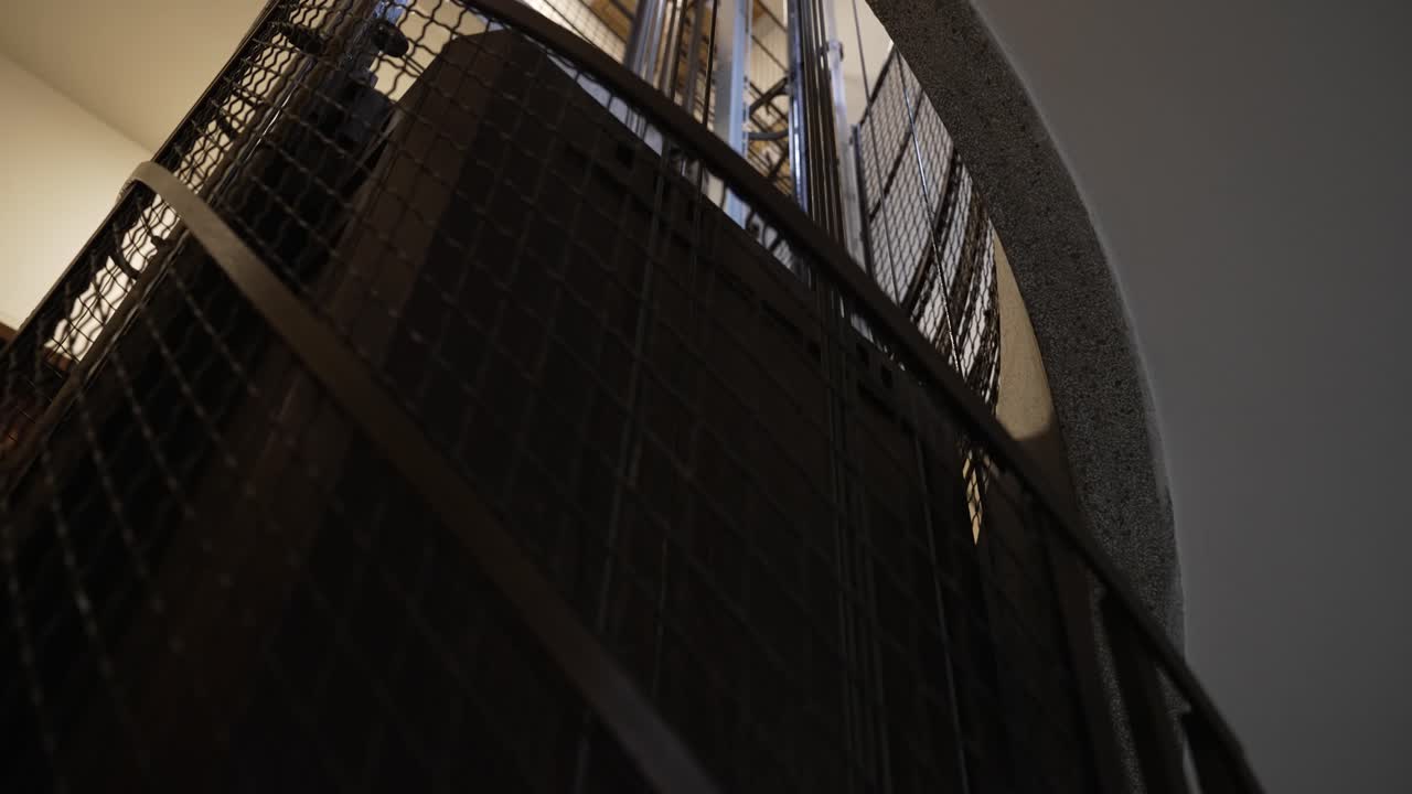 Looking up an old elevator shaft from the stairway as it ascends through a building