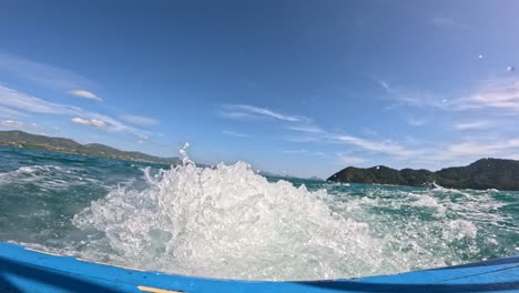 a dynamic boat journey across choppy waters near phuket, thailand, under clear skies with distant islands in view