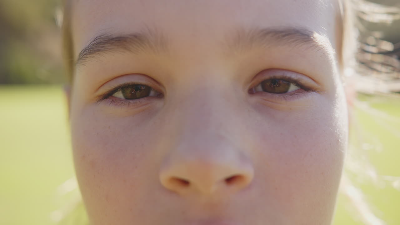 Close-up of girls face, focusing on eyes, outdoors in school setting