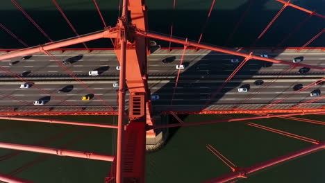 aerial top-down view of a red suspension bridge with traffic