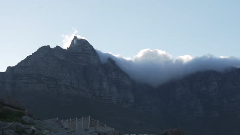 Large-Cloud-rolling-over-a-Mountain-with-sun-shining-trough-the-clouds