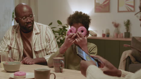 hombres negros y niños divirtiéndose mientras comen en casa.