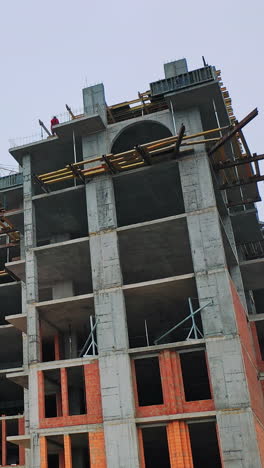construction of high-rise building. front view of huge building in the process of construction. new construction site in the city. vertical video