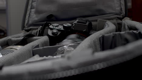 close up of the hands of a photographer as he packs his lens and camera equipment into his bag in preparation for an upcoming shoot