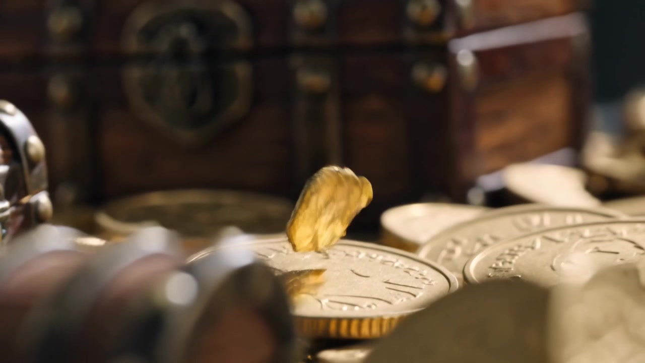 Falling thin golden piece rotating as gravity pulls, settling on coins on table near wooden chests