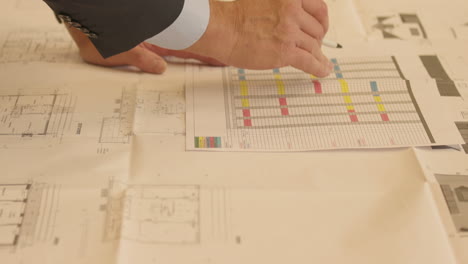 hombre señalando el plano de planta en la oficina