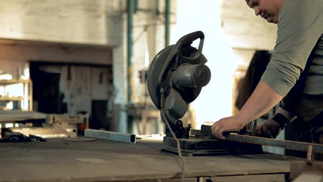 blacksmith saws metal with a circular saw. equipment for cutting metal. sparks fly. close-up