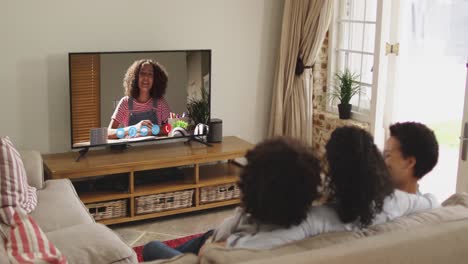 African-american-family-having-a-video-call-on-tv-while-sitting-on-the-couch-at-home