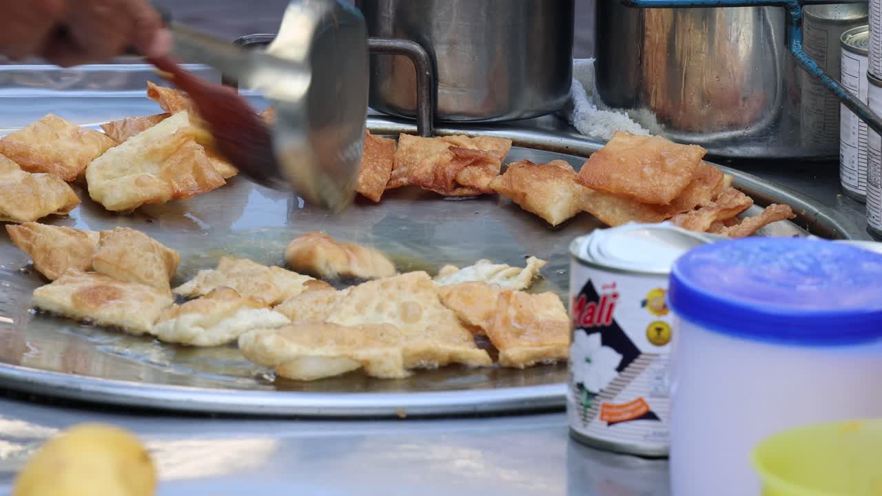 cocinar y voltear bocadillos fritos en una sartén grande