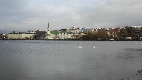 Frikirkjan-church-seen-from-shore,-Iceland,-Reykjavik,-dolly-in,-cloudy-day