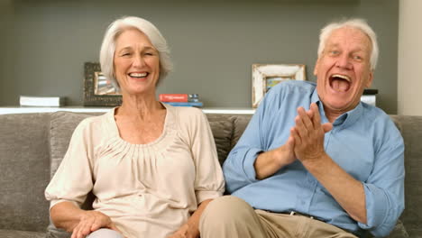 elderly couple laughing and looking to the camera