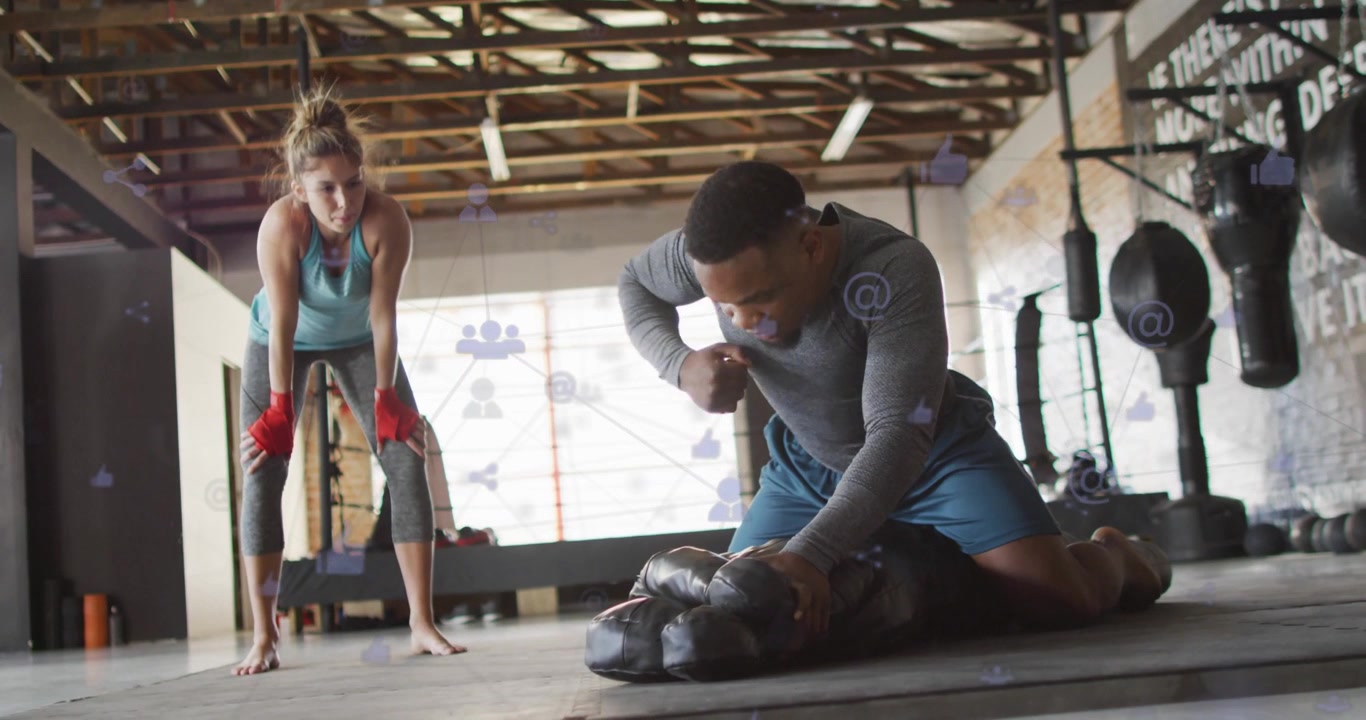 Trainer positioning mannequin kneeling and doing CPR for training in gym, icons overlaying