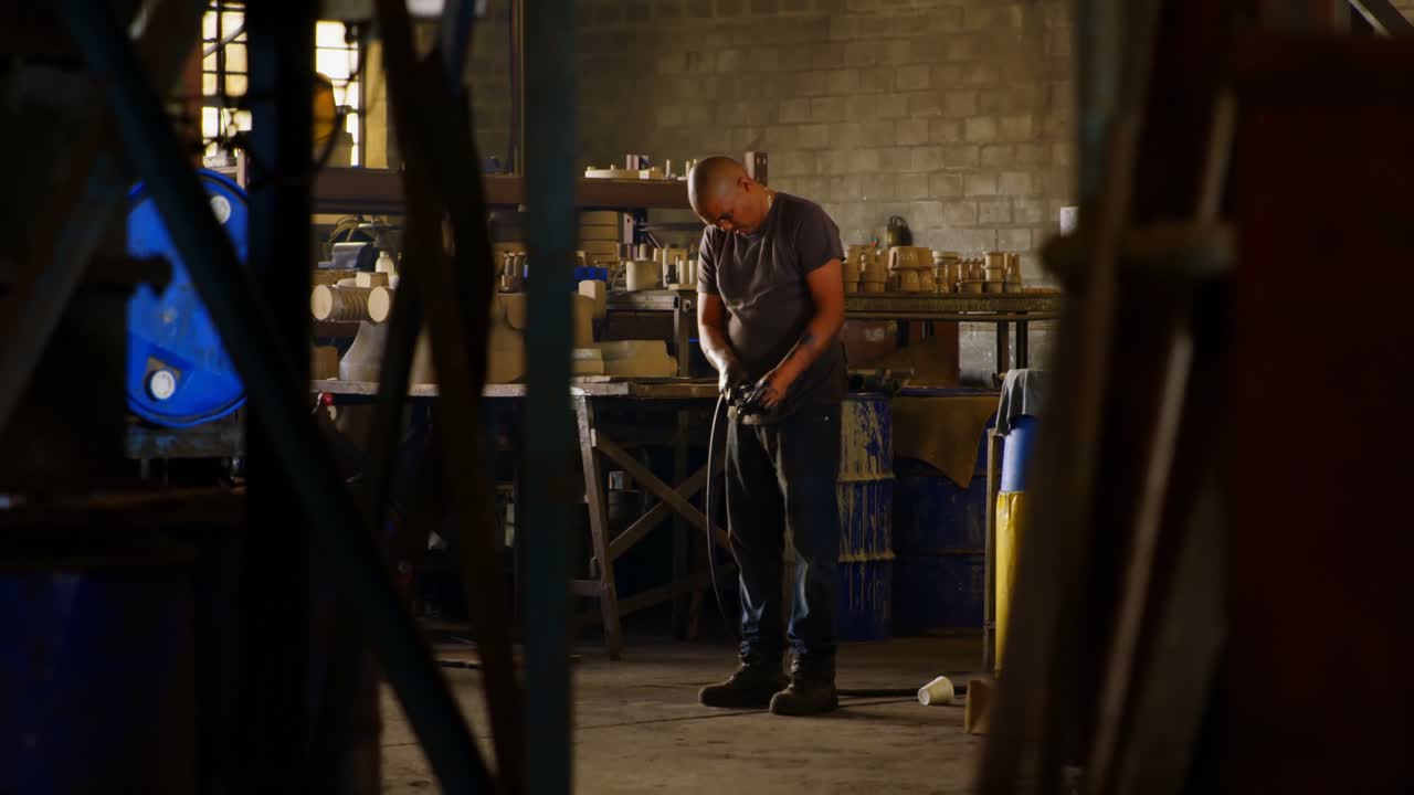 Worker working with pipe in foundry workshop 4k