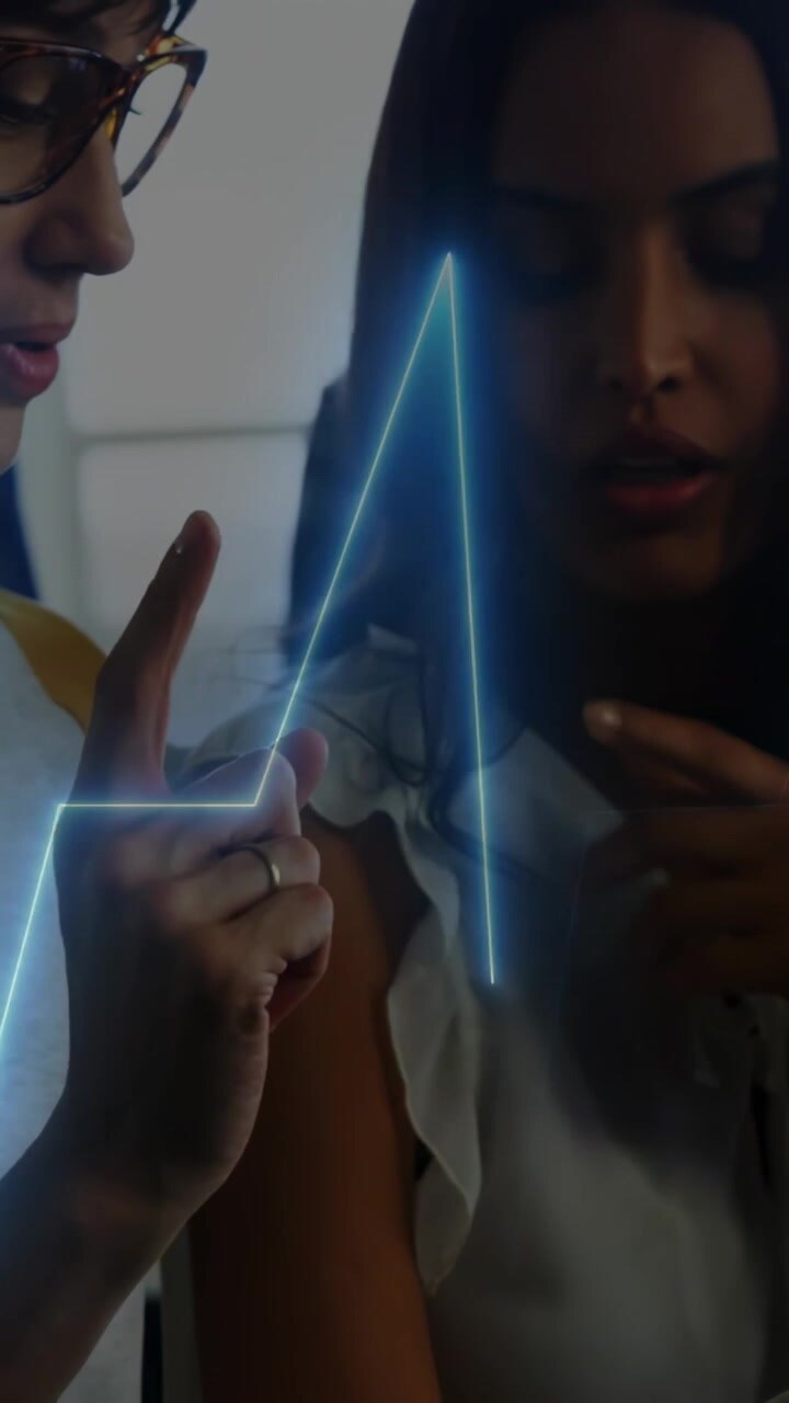 Vertical video: User tapping tablet causing ECG overlay reading health glassed peer pointing aboard