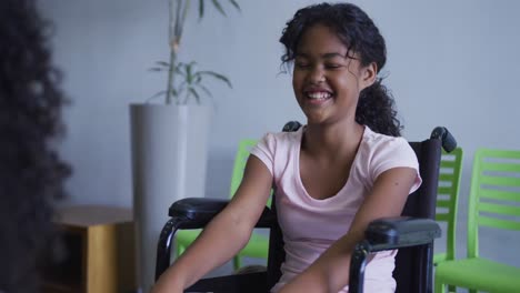 Niña-Afroamericana-Sonriendo-Mientras-Está-Sentada-En-Una-Silla-De-Ruedas-En-El-Hospital