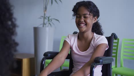 african american girl smiling while sitting on a wheelchair at hospital