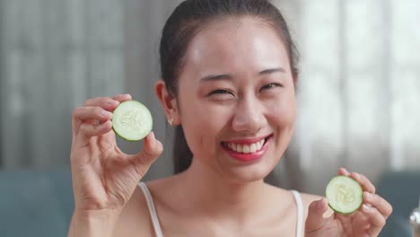 woman using cucumber slices for facial treatment