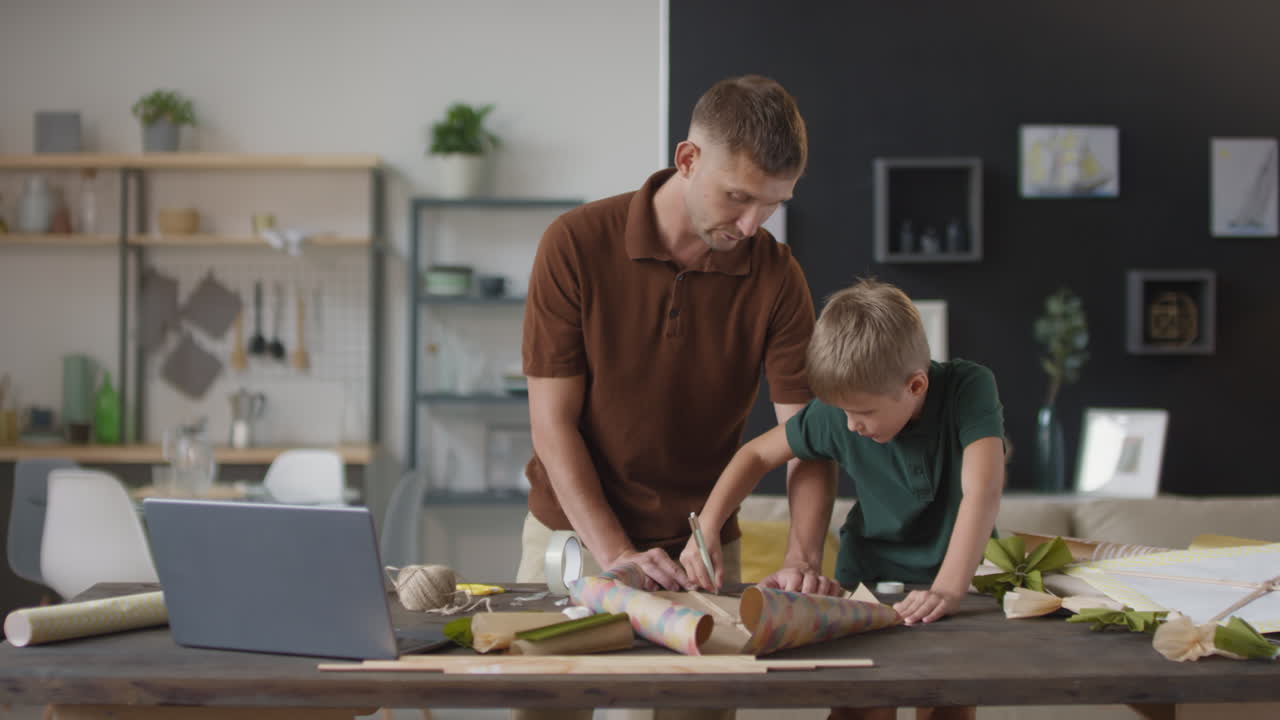 padre e hijo haciendo una cometa juntos