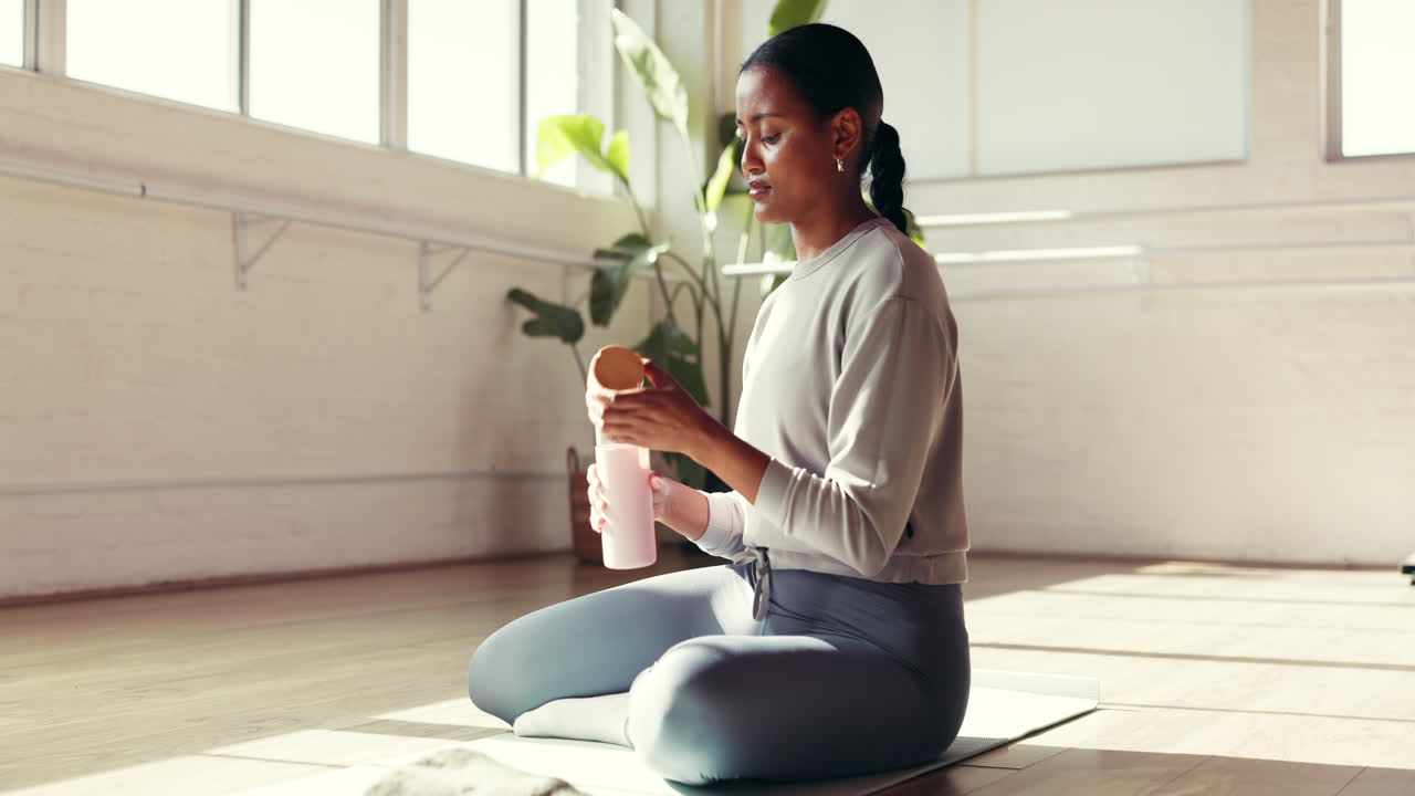 Woman drinking water after yoga