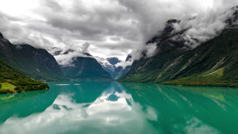 Drone-hyperlapse-over-Loen-Lake-of-mountain-fog-twirling-around-Loen-mountains