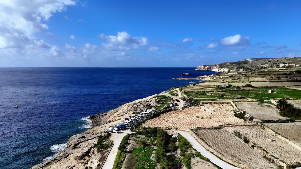Vista costiera di Gozo, Malta con campi e scogliere sotto cieli azzurri