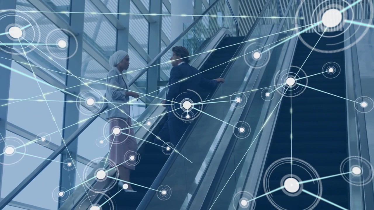 Two professionals riding escalators in corporate atrium, showing digital network connections