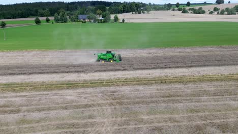 a view of efficient combined harvesting in action when the camera from the drone captures the harvester and rotates around it