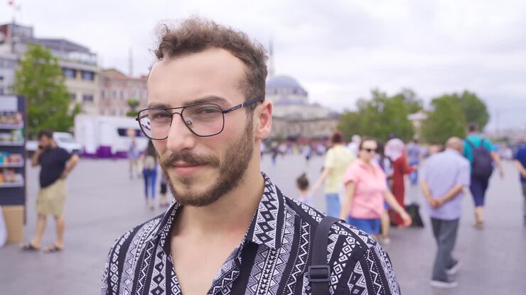 Uomo che guarda in camera in una strada affollata