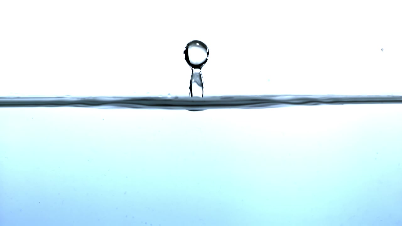 Slow Motion Close-up of a Water Droplet Falling into Clear Water