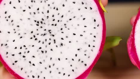 hands cut and reveal dragon fruit interior