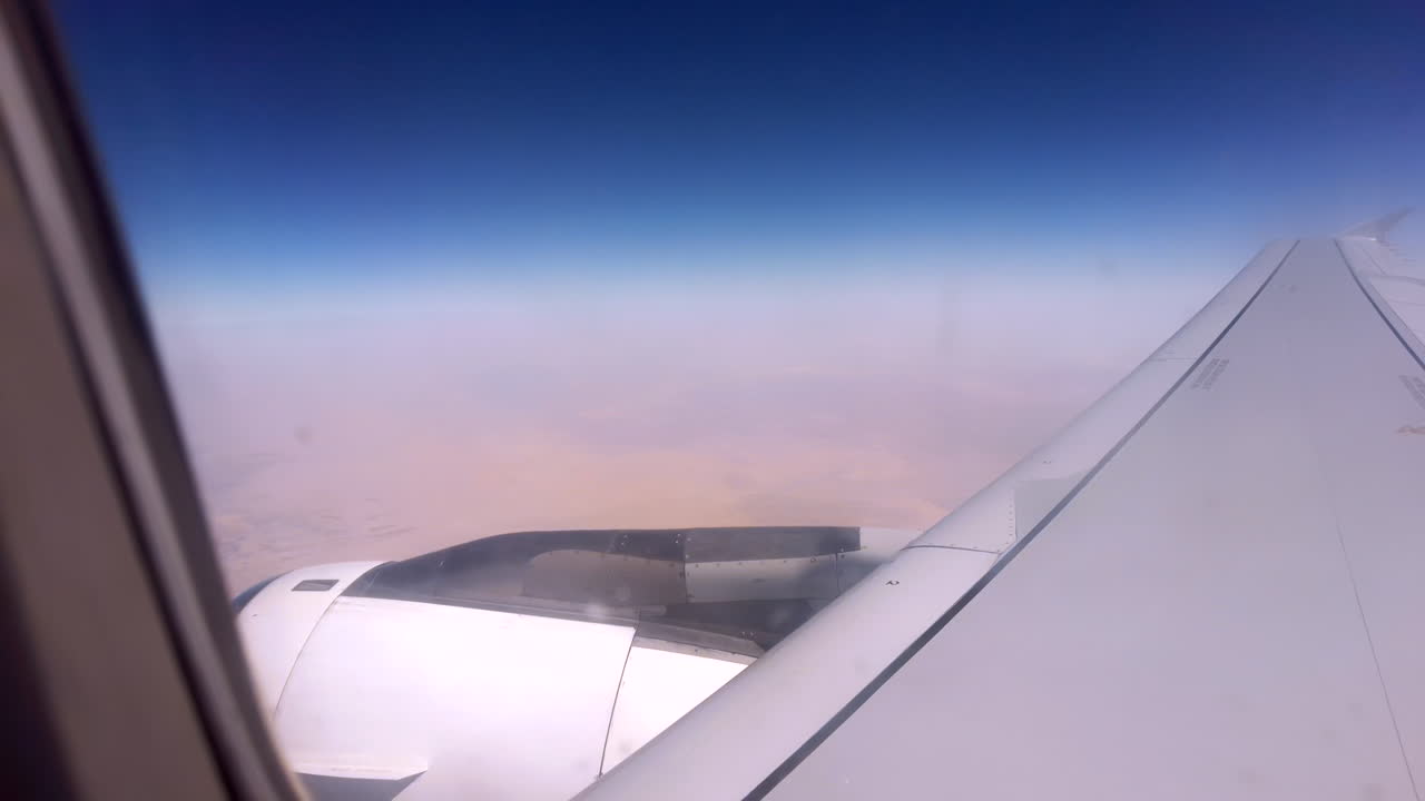 View from an airplane window of the aircraft wing in the clouds
