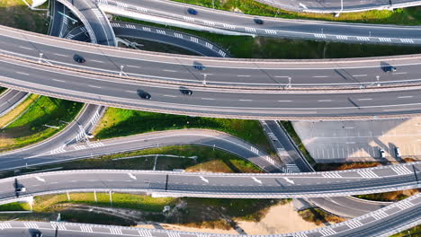 traffic moves on europe's roads. multiple vehicles navigate intricate highways and ramps in a vibrant european landscape under a clear sky