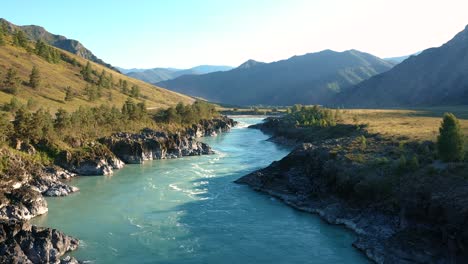 aerial flying over surface of mountain river with turquoise water rocky shores