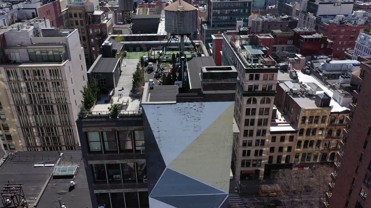 A high angle view of the buildings in Greenwich Village, NY. It's a sunny day, as the camera views the horizon, then tilt down to a geometric pattern, colorfully painted on the facade of a building.