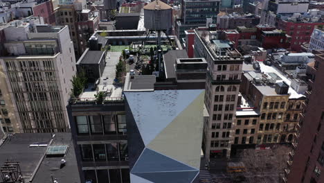 a high angle view of the buildings in greenwich village, ny. it's a sunny day, as the camera views the horizon, then tilt down to a geometric pattern, colorfully painted on the facade of a building.