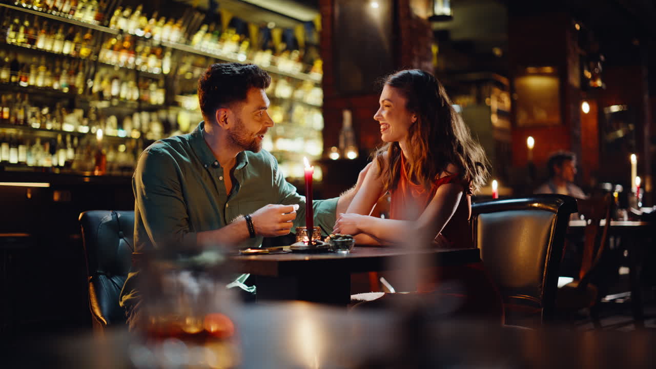 Coppie felici che guardano il menu e trascorrono una serata romantica in un bar. Uomo e donna sorridenti