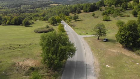 Un-Dron-Aéreo-Disparó-Sobre-Una-Carretera-Extraurbana-Y-Un-Automóvil-Cuesta-Arriba-1