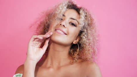 woman with curly blonde hair in off-the-shoulder top