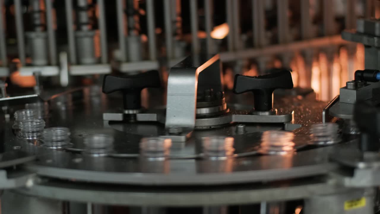 Automatic filling machine pours water into plastic PET bottles at modern beverage plant