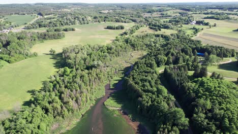 Flying-Over-Small-Forest-and-Leaf-Shaped-Lake-River-Rural-Ontario-Canada